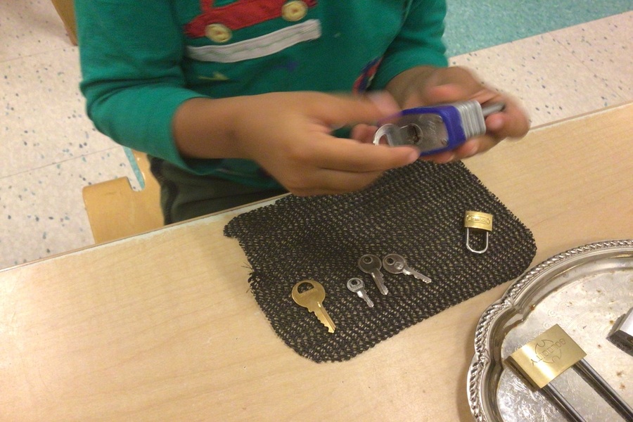 A child inserting a key into a padlock