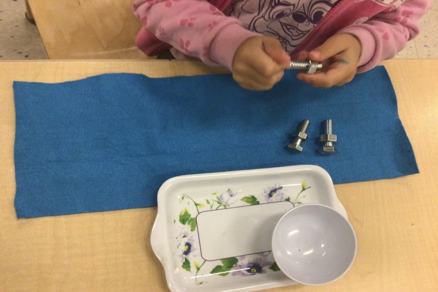 A child working with a bolt and nut