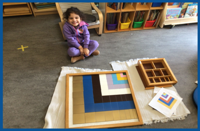 A child sitting with a completed Pythagoras Square and worksheet