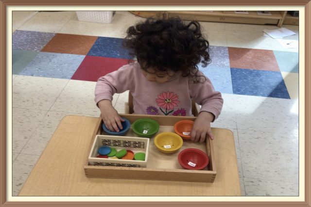 A child placing a blue disc in a small blue bowl