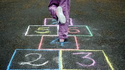 A child hopping onto the 4 rectangle in hopscotch