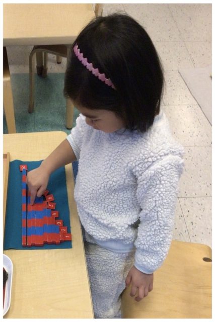 A child working with the small number rods