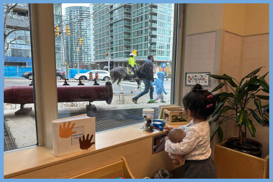 A child observing a police horse and police officer outside