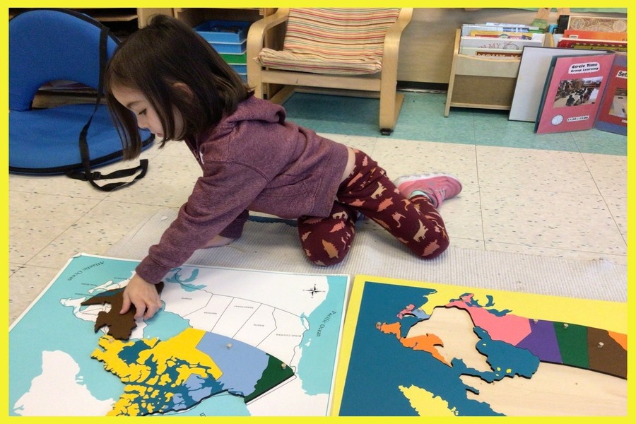 A child placing puzzle pieces of a continent onto a control card