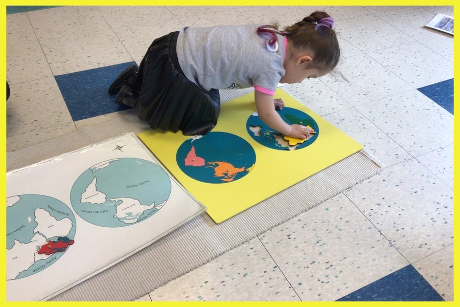 A child working on a puzzle map of the continents