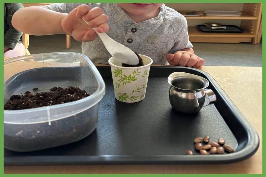 A child scooping soil into a paper cup