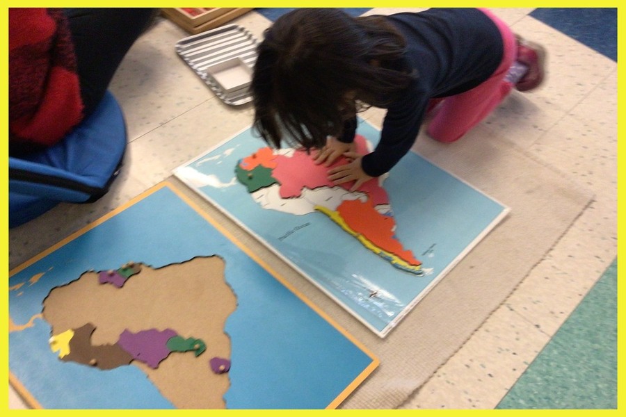 A child working on a puzzle map of Africa