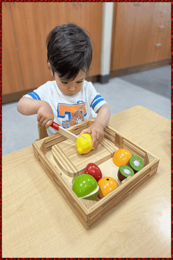 A child cutting a velcro lemon in half with a wooden knife