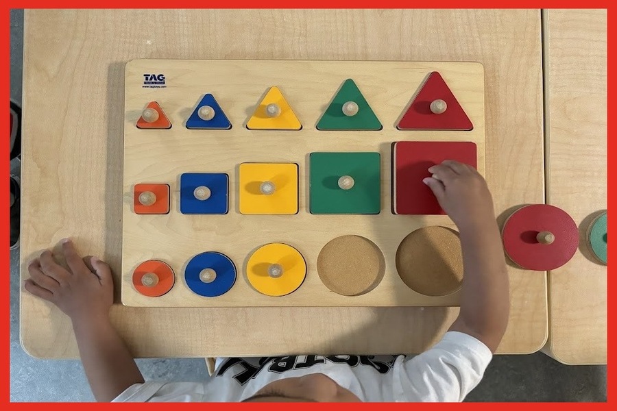 A child placing a large red square in a shape puzzle