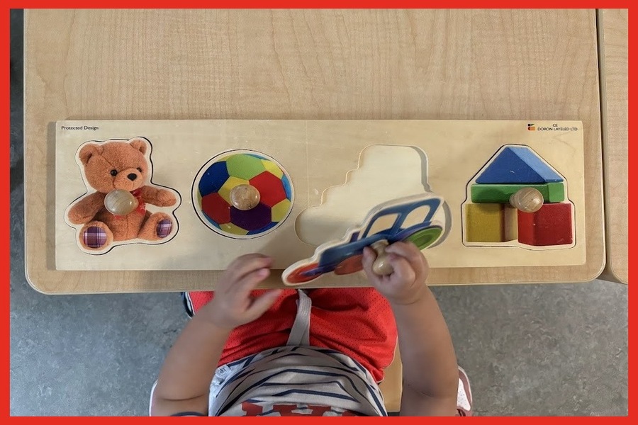 A child using a large knob puzzle