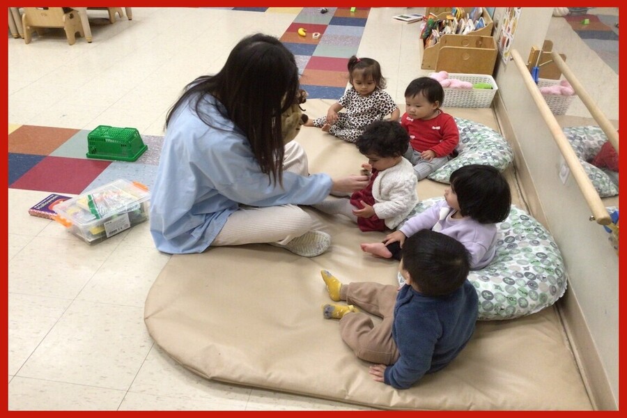 A child looking closely at a monkey finger puppet from the 5 Little Monkeys hand puppet