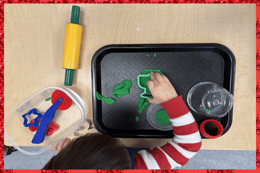 A child cutting shapes out of playdough with a cookie cutter