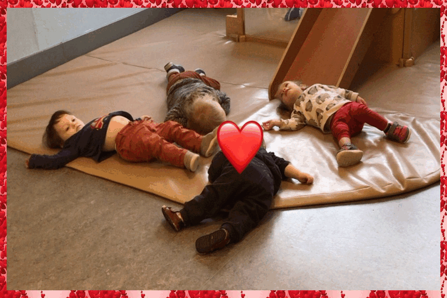 Children lying on a mat acting out 'Sleeping Bunnies'