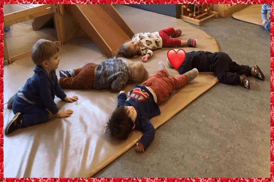 Children lying on a mat acting out 'Sleeping Bunnies'