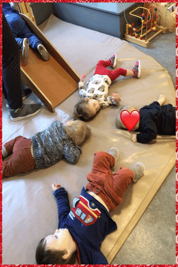 Children lying on a mat acting out 'Sleeping Bunnies'