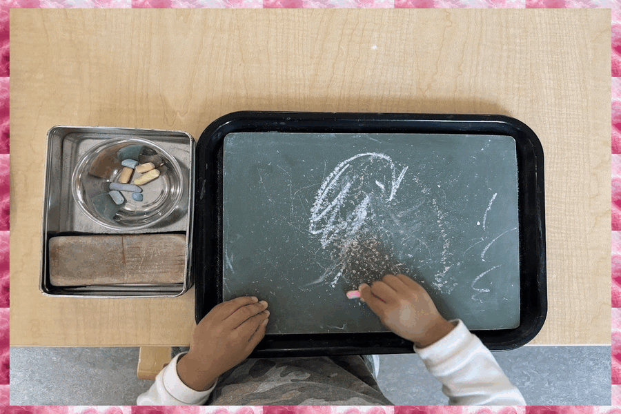 A child colouring with chalk on a board