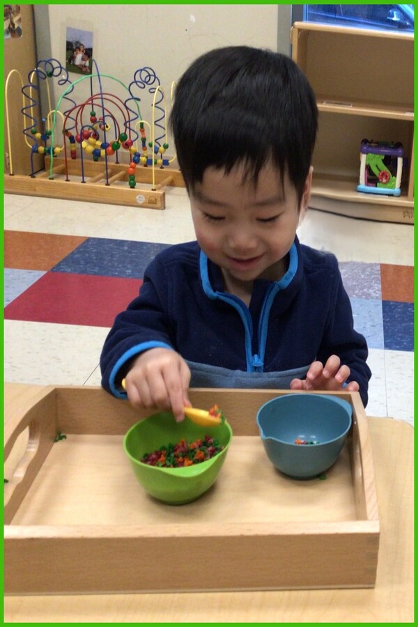 A child spooning rice from bowl to bowl